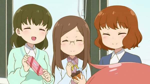 小林にチョコレートを差し出す3人の女性同僚。手前に小林の後頭部が見える